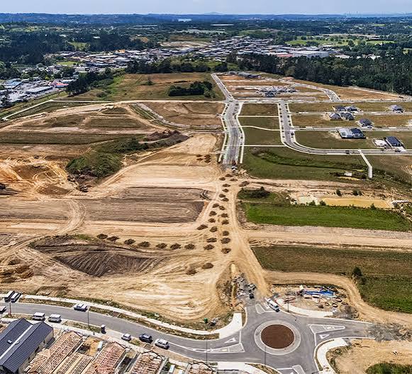 Aerial view of a large Auckland subdivision under construction with bulk earthworks and new roading